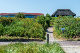 View of Cley marshes visitor centre from the marshes.