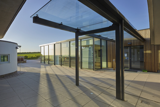 The outside of a glass building and courtyard on a sunny day