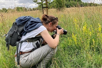 Gail Ashton photographing invertebrates in a grassy field