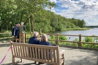 A couple sat on a new bench at Rollesby Broad looking out over the water.