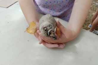 A child's hands holding a clay craft animal