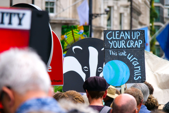 A placard at the Restore Nature Now march in London that says, 'clean up your crap this isn't uranus'.