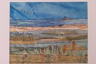 Artwork depicting fields, sea and a boat on the horizon, created using textile and stitch