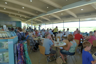 Visitors sitting down to eat and drink at the cafe in the visitor centre at Cley