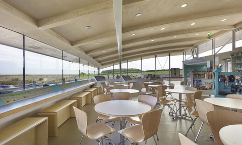 Tables and chairs looking out over Cley marshes inside the Cley visitor centre