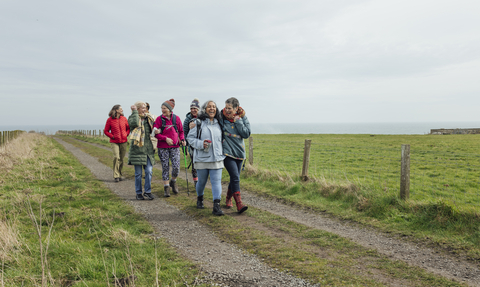 A group of women walking along a costal footpath