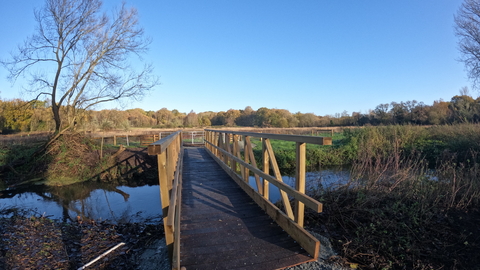 A wooden bridge across a stretch of water on a sunny day