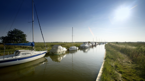 Small, white boats on the Broad at Upton Broad and Marshes on a sunny day