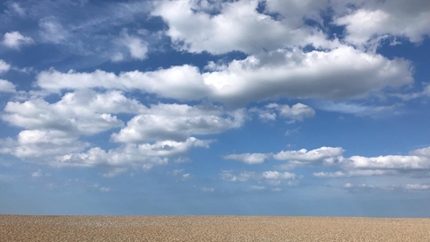 Cley shingle beach on a sunny day with fluffy white clouds