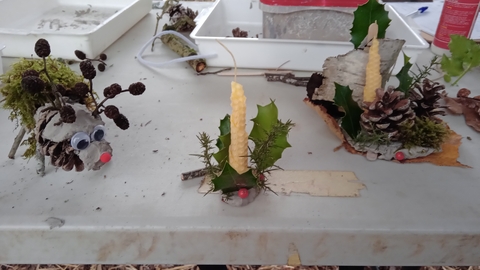 Christmas crafts made from clay and natural materials sit on a white table