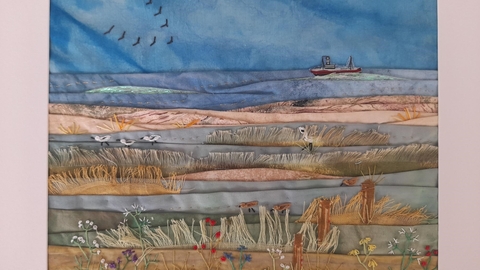 Artwork depicting fields, sea and a boat on the horizon, created using textile and stitch