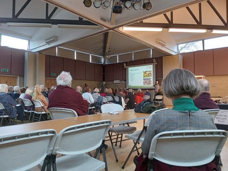 Attendees sat in chairs looking at a presentation at the conference. 