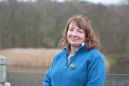 Eilish has short auburn hair and is smiling in a blue fleece on the broad. 