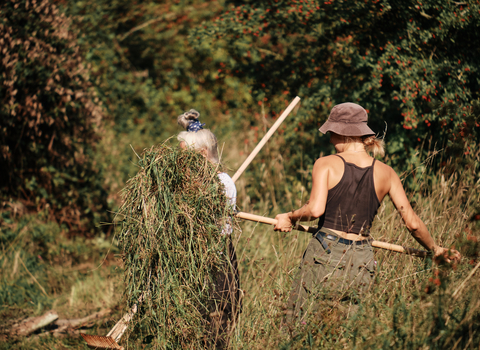 Volunteers raking on a sunny day at Sweet Briar Marshes