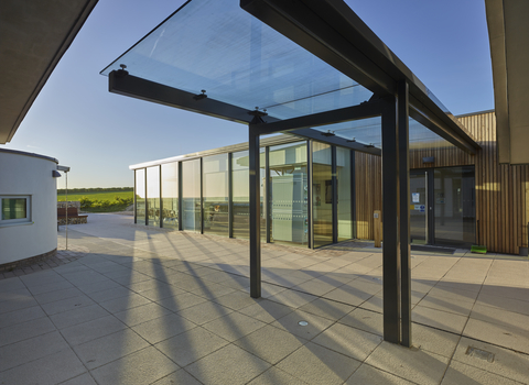 The outside of a glass building and courtyard on a sunny day